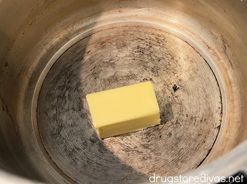 Half a stick of butter in a silver stockpot.