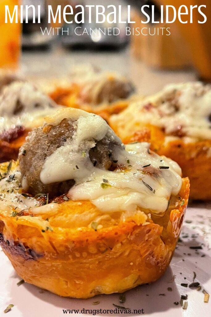 Three meatballs in biscuit cups with mozzarella on top and the words "Mini Meatball Sliders With Canned Biscuits" digitally written on top.