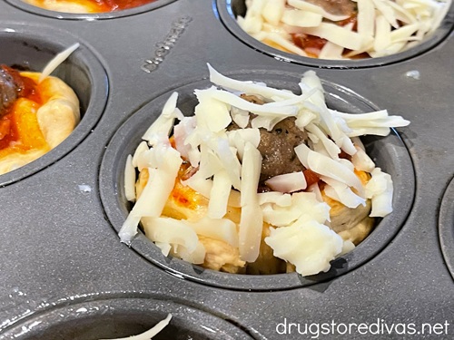 Mozzarella grated on top of muffin tins.