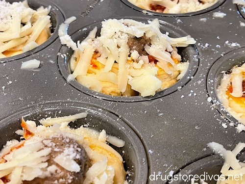 Grated mozzarella and parmesan cheese on top of muffin tins.