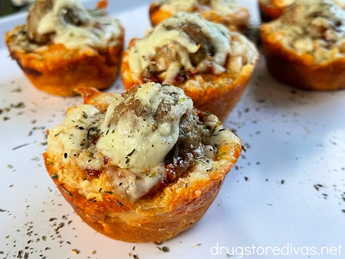 Baked mini meatball sliders in canned biscuits on a white tray.