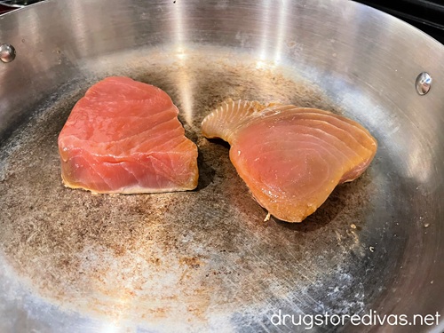 Two tuna steaks in a silver pan.