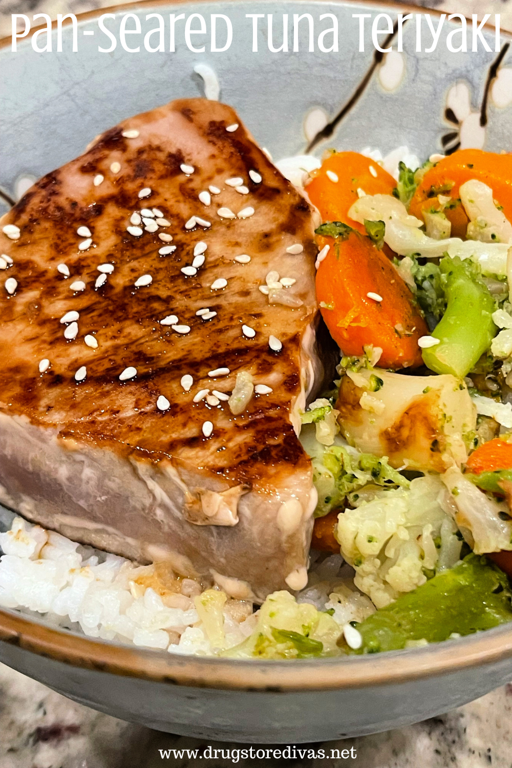 A piece of tuna steak with sesame seeds on it next to vegetables on top of rice in a blue bowl with the words 