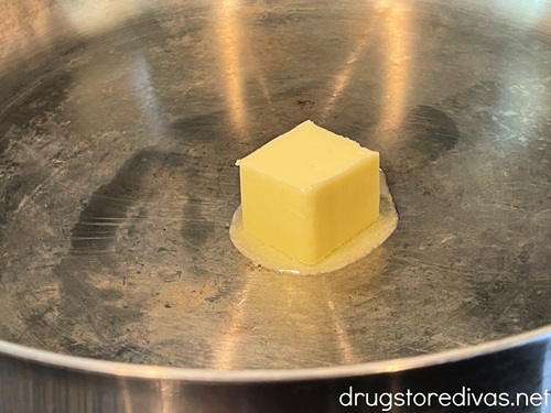 A square of melting butter in a silver skillet.