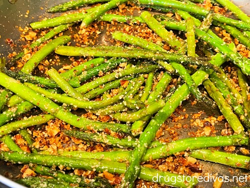 Asparagus and chopped almonds in a pan.