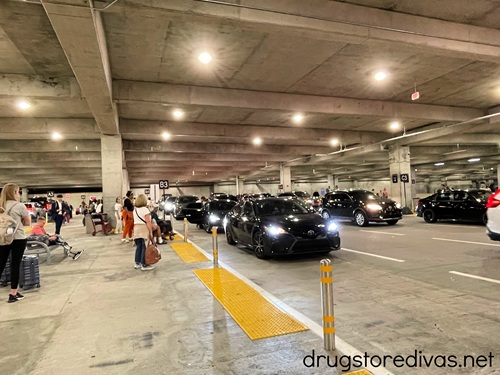 Riders waiting to be picked up by rideshare drivers in the parking lot at the Nashville Airport.