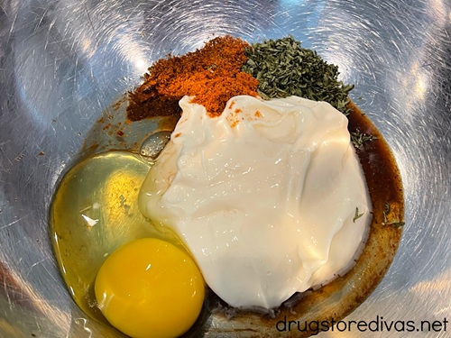 Mayo, egg, and seasoning in a metal bowl.