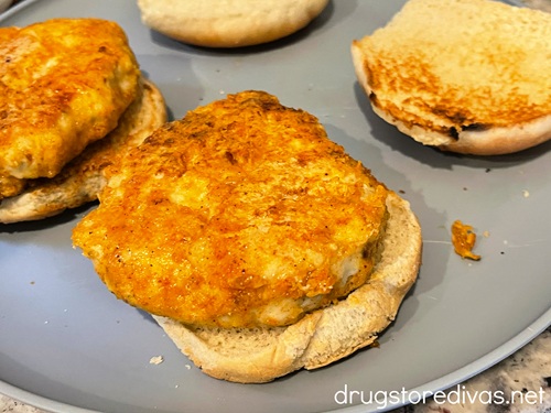 Two cooked chicken patties on buns.