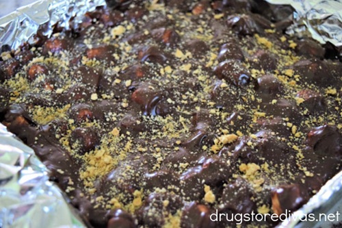 Graham cracker crumbles on top of chocolate fudge in a foil lined pan.