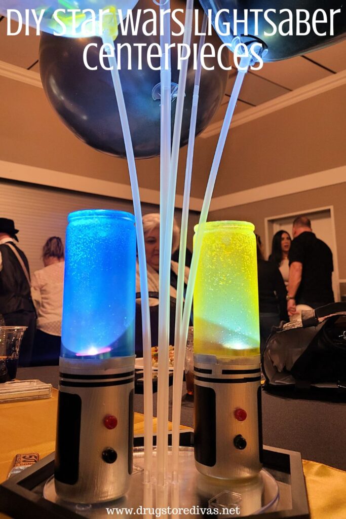 A blue and yellow DIY lightsaber on a mirror as a party centerpiece with the words "DIY Star Wars Lightsaber Centerpieces" digitally written on top.