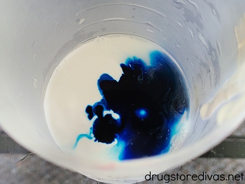 Mod Podge and blue food coloring in a cup.
