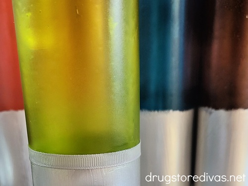 Painted candles with a silver ribbon wrapped around them.