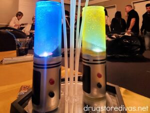 Two DIY Star Wars Lightsabers on top of a hexagon mirror, set up as a party centerpiece.