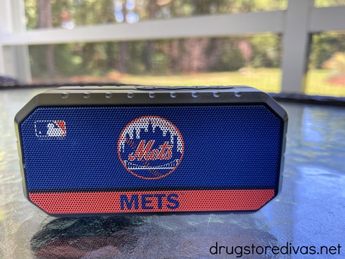 A New York Mets-branded Bluetooth speaker on a glass table.