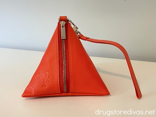 An orange triangle shaped wallet with a New York Mets logo on it.