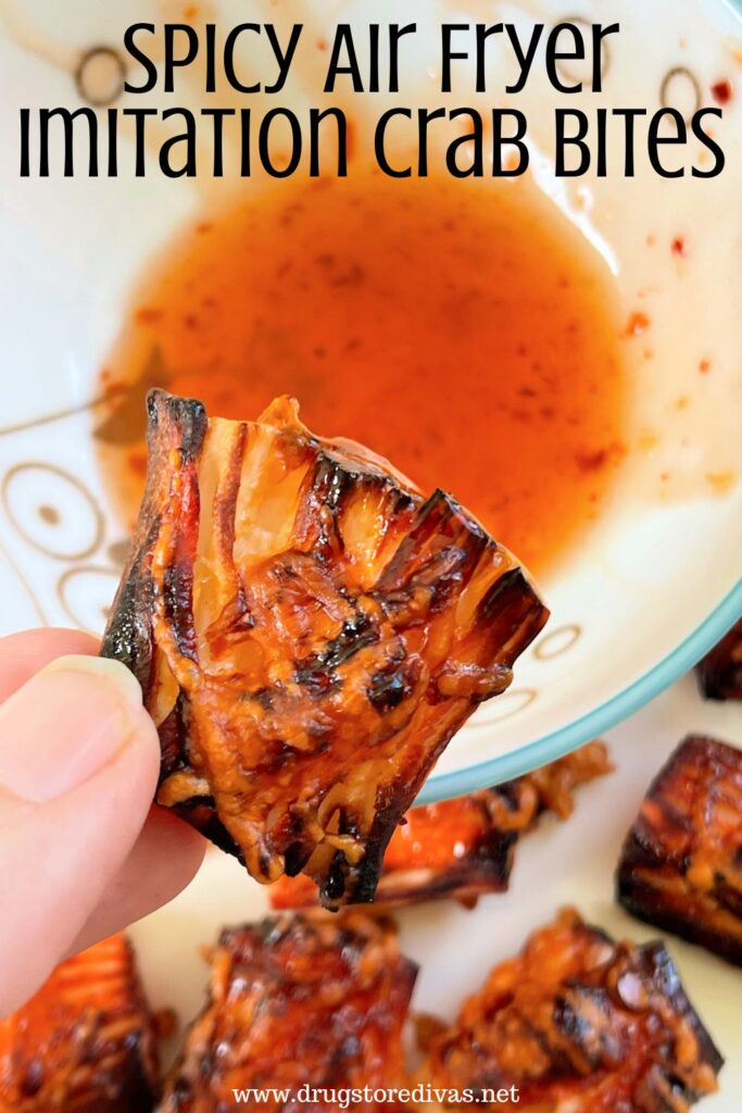 A hand holding a crab bite square above some red sauce in a bowl with the words "Spicy Air Fryer Imitation Crab Bites" digitally written on top.