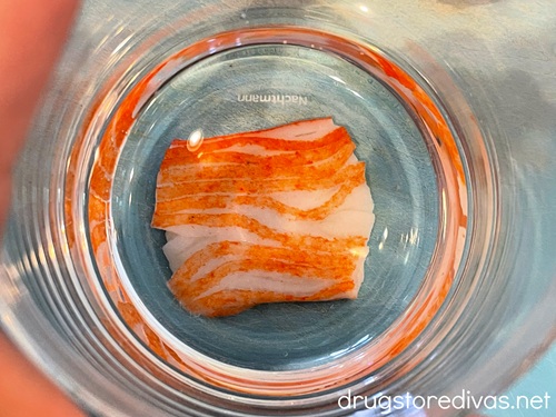 A glass on top of a piece of imitation crab meat.