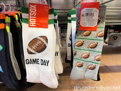 Two pairs of football-themed socks hanging on pegs in a store.