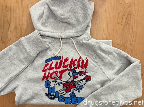 A gray sweatshirt with a cartoon chicken playing a guitar on it with a Tennessee Titans logo.