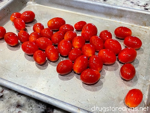 Cherry tomatoes on a silver baking sheet.