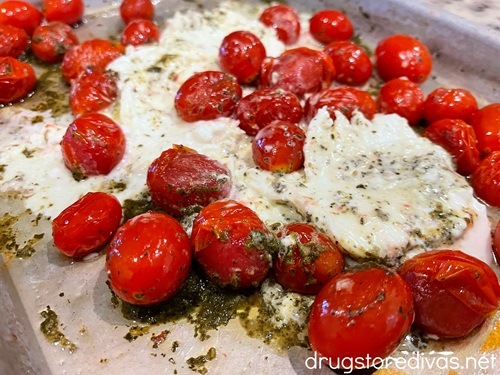 Roasted tomato burrata salad on a silver tray.