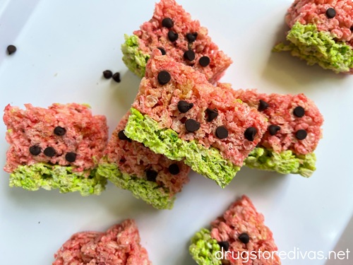 Two watermelon rice krispies treats on a green cutting board.