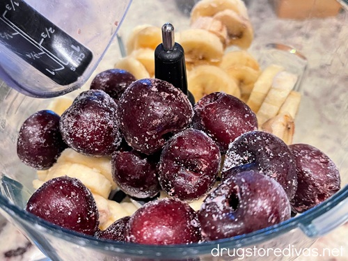 Cherries and banana slices in a blender.
