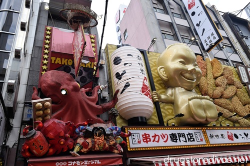 A giant octoous, ninja, lantern, Bilikin, and fake food above shops in Dotonbori Japan.