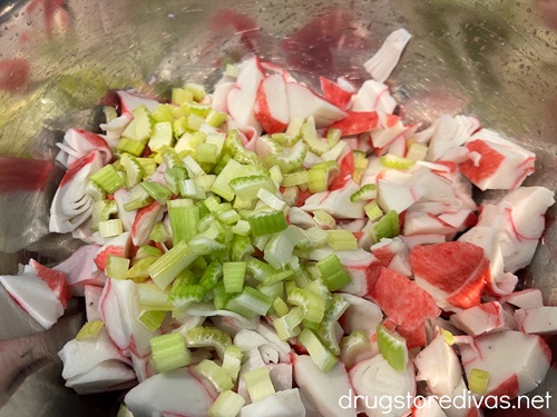 Imitation crab and celery pieces in a silver bowl.