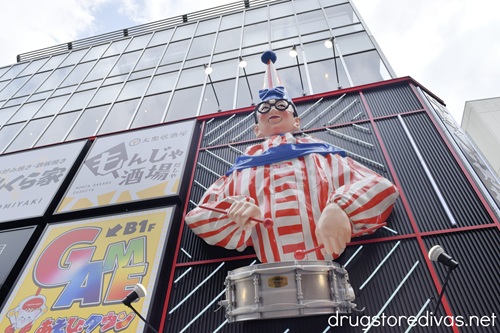An animatronic Kuidaore Taro (a clown in a red and white striped outfit with a drum) on a building in Dotonbori Japan.