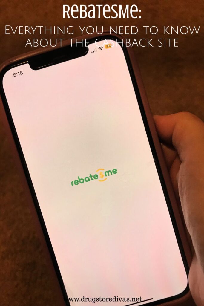 A hand holding a phone with a white screen that says RebatesMe and the words "RebatesMe: Everything you need to know about the cashback site" digitally written on top.