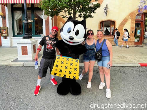 A man and two women posing with a Felix the Cat character in Universal Studios Japan.