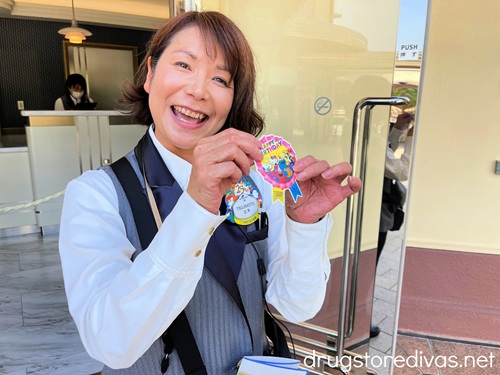 A Japanese woman holding up a sticker that says Happy Birthday at Universal Studios Japan.
