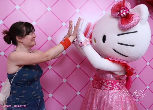 A woman and Hello Kitty giving each other two high fives at Universal Studios Japan.