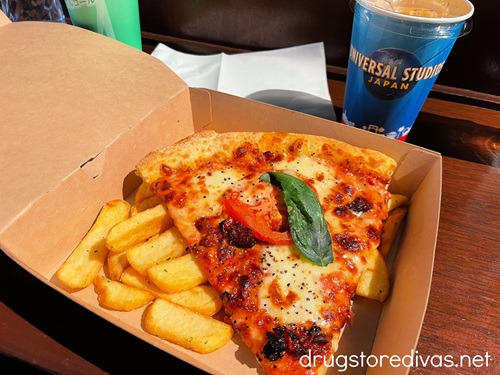 A slice of pizza, steak fries, and a drink from Universal Studios Japan.