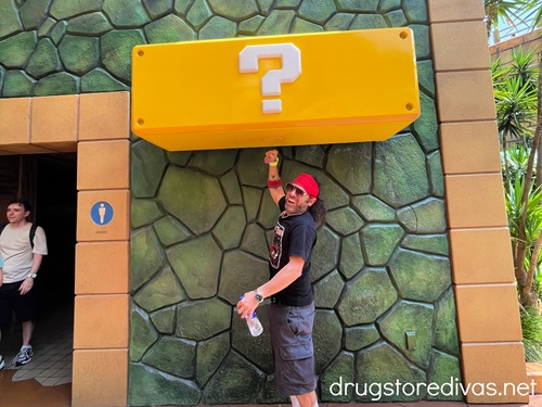 A man wearing a Power-Up Band and jumping to hit a Question Box at Super Nintendo World in Universal Studios Japan.