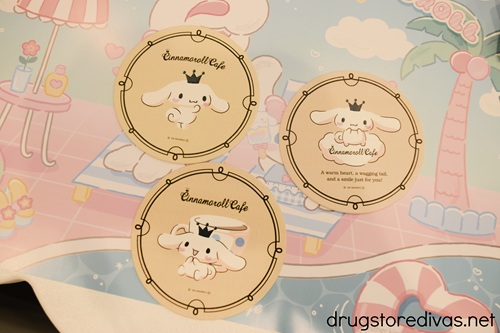 Three brown Cinnamoroll coasters on a placemat.