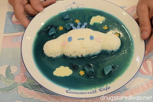 A plate of blue curry with the rice shaped like Cinnamoroll.