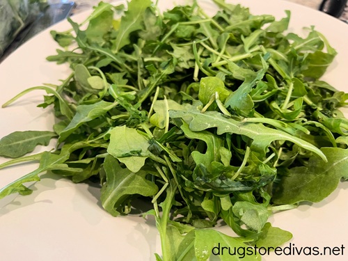 Arugula on a white serving tray.