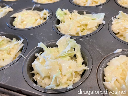 Shredded cabbage in cavities in a muffin pan.