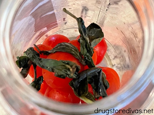 Cherry tomatoes and basil in a glass jar.