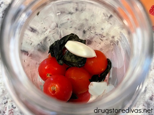 Cherry tomatoes, basil, and garlic in a glass jar.