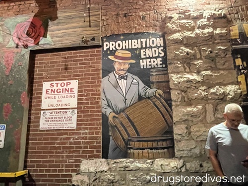 A mural of a man carrying barrels with the words "Prohibition Ends Here" on a brick wall outside Alley Taps in Nashville.