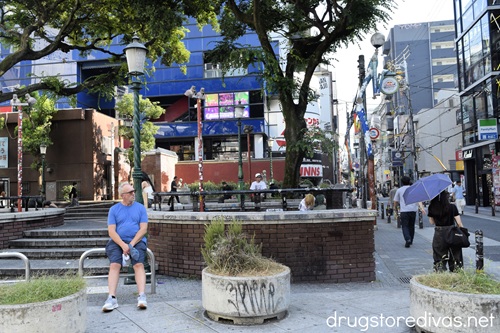 A man sitting in front of a concrete park in Amerikamura, Japan.