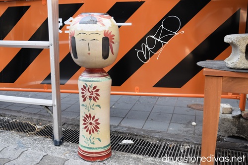 A large wooden kokeshi doll on a street in Amerikamura, Japan.